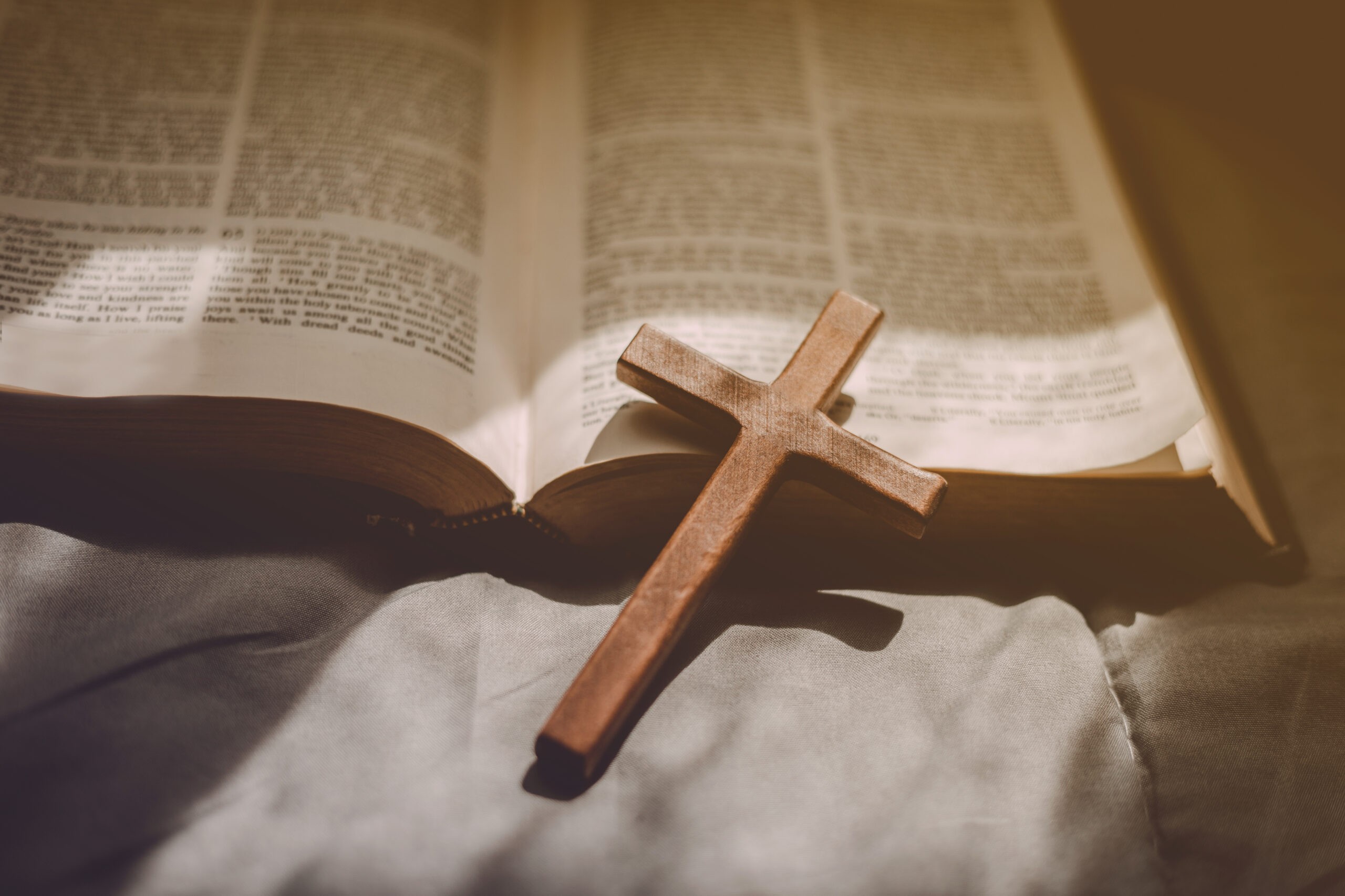 Crucifixion of Jesus christ ,cross with the holy bible at sunlig